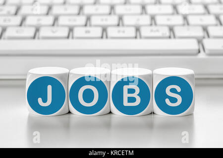 Buchstabenwürfel vor einer Tastatur - Jobs Stockfoto