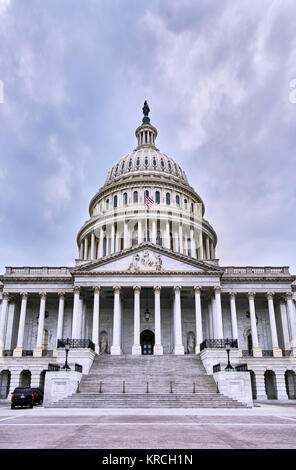 United States Capitol Gebäude Fassade mit zwei Secret Service Fahrzeuge außerhalb, leere Plaza, und keine Leute auf dunklen bewölkten Tag sichtbar. Washington, D.C., USA Stockfoto