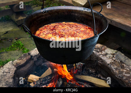 Traditionelle Ungarische Gulaschsuppe in Kessel. Mahlzeit gekocht im Freien auf einem offenen Feuer. Lecker und gesund Essen beliebt in Mitteleuropa Stockfoto