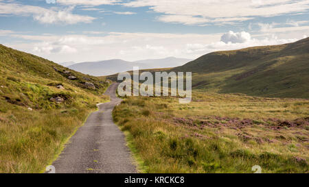 Ein schmaler Pass Road kreuzt Moor auf Caherconree im Slieve Mish Mountains der Halbinsel Dingle in der Grafschaft Kerry in Irland. Stockfoto