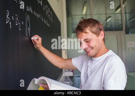 Hübsche Studentin eine mathematisches Problem zu lösen, während der Math-Klasse vor der Tafel/Tafel (getönten Farbbild) Stockfoto
