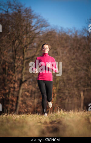 Junge Frau im freien laufen an einem schönen sonnigen Tag Winter/Herbst Stockfoto