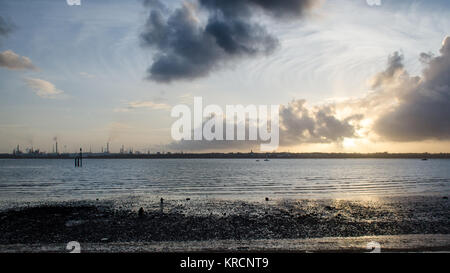 Den Sonnenuntergang Silhouetten der industriellen Türme von Fawley Ölraffinerie am Ufer des Southampton Wasser, von netley gesehen. Stockfoto