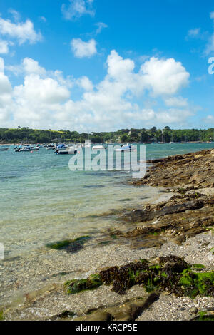 Mit Blick über die malerische Helford River, wo viele kleine Boote zwischen Helford Dorf und Helford Passage in Cornwall, UK vor Anker liegen. Stockfoto