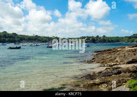 Mit Blick über die malerische Helford River, wo viele kleine Boote zwischen Helford Dorf und Helford Passage in Cornwall, UK vor Anker liegen. Stockfoto