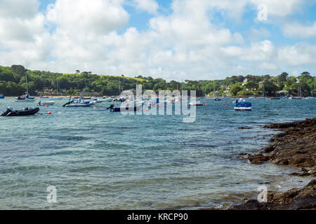 Mit Blick über die malerische Helford River, wo viele kleine Boote zwischen Helford Dorf und Helford Passage in Cornwall, UK vor Anker liegen. Stockfoto