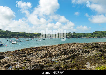 Mit Blick über die malerische Helford River, wo viele kleine Boote zwischen Helford Dorf und Helford Passage in Cornwall, UK vor Anker liegen. Stockfoto