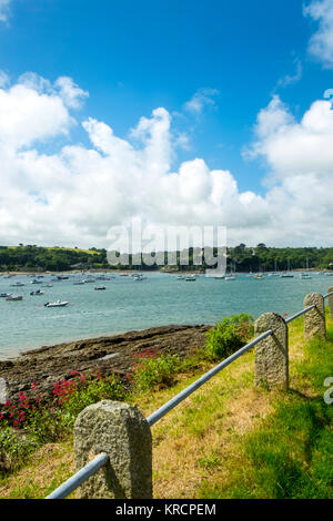 Mit Blick über die malerische Helford River, wo viele kleine Boote zwischen Helford Dorf und Helford Passage in Cornwall, UK vor Anker liegen. Stockfoto