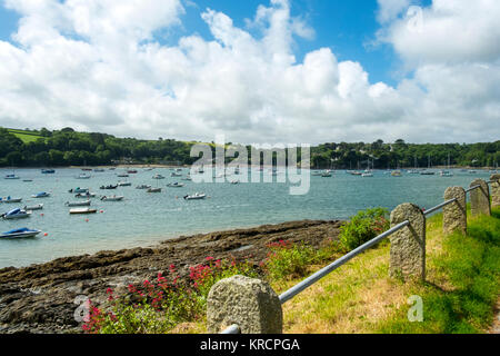 Mit Blick über die malerische Helford River, wo viele kleine Boote zwischen Helford Dorf und Helford Passage in Cornwall, UK vor Anker liegen. Stockfoto