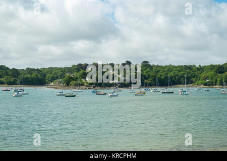 Mit Blick über die malerische Helford River, wo viele kleine Boote zwischen Helford Dorf und Helford Passage in Cornwall, UK vor Anker liegen. Stockfoto