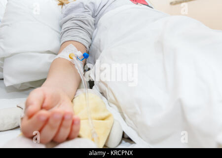 Kleines Mädchen ist Medikament durch intravenöse Therapie im Krankenhaus, Bett, Fokus auf Tropfen. Stockfoto