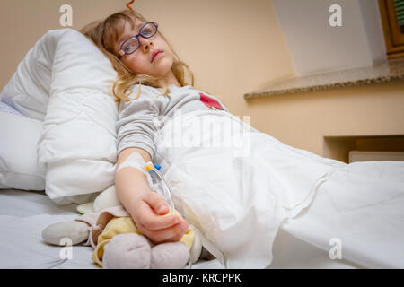 Kleines Mädchen ist Medikament durch intravenöse Therapie im Krankenhaus, Bett, Fokus auf Tropfen. Stockfoto