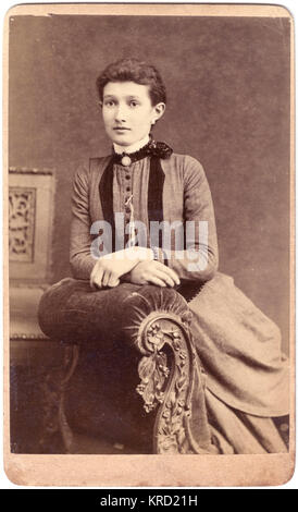 Junge viktorianische Frau, die auf einer Chaiselongue sitzt Stockfoto