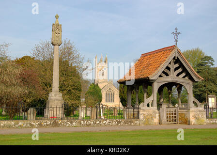 Blick auf die St. Nikolaus Kirche, Fulbeck, Lincolnshire, über vom Friedhof gesehen, mit einem Stein Kreuz und einem lych Gate im Vordergrund. Stockfoto