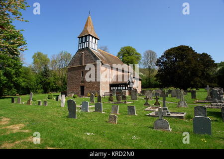 St. Michael and All Angels Church, eine normannische Kirche in Castle Frome, Herefordshire, von der anderen Seite des Friedhofs aus gesehen. Der Geschützturm wurde im 19. Jahrhundert hinzugefügt. Stockfoto