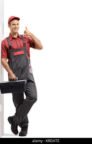 In voller Länge Porträt der Handwerker mit einer Toolbox einen Anruf machen mich Geste und lehnte sich gegen eine Wand auf weißem Hintergrund Stockfoto