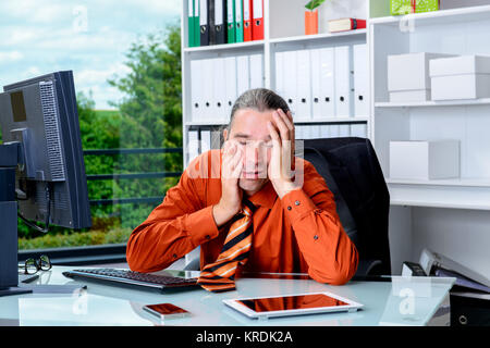 Junge müde Geschäftsmann liegend mit dem Kopf in den Händen ist über-arbeitete Stockfoto