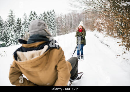 Mein Großvater und mein kleines Mädchen Rodeln an einem Wintertag. Stockfoto