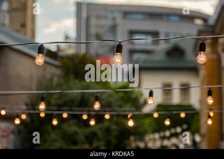 Glühlampen in einem Garten - Sommer Party und Kultur Konzept Stockfoto