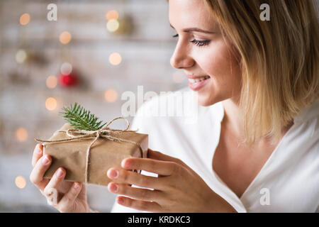 Junge Frau mit eingewickelt Weihnachtsgeschenk. Stockfoto