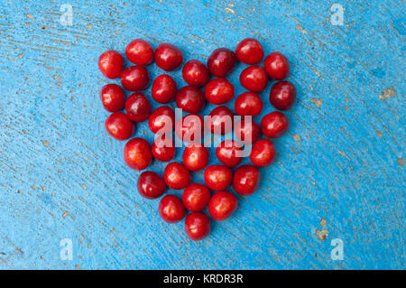 Herzförmige Kirschen auf blauem Hintergrund cherry Herz Stockfoto