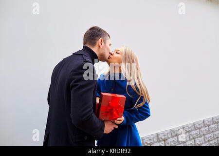 Ein liebevolles Paar gibt ein Geschenk in einer Box. Stockfoto