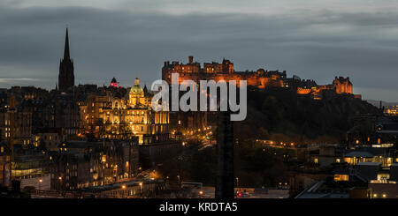 Blick über Edinburgh City in der Dämmerung mit Edinburgh Schloss auf Castle Rock lite im Abstand von Carlton Hill gesehen. Stockfoto