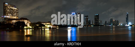 Bangkok bei Nacht Skyline von unter Rama 3 Brücke, den Fluss Chao Phraya. Stockfoto