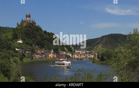 Blick über die Mosel und die Reichsburg in Cochem mit Personenschiff Kloster Machern 5/6 einer straßenmeister Kahle Linde und Wegekreuz, aufgehender Vollmond Sonnenuntergang im Winter über dem Ebbegebirge bei Meinerzhagen, unbearbeitete Originalfarben Stockfoto