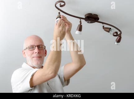 Mann Ersetzen der Glühbirne zu Hause Stockfoto