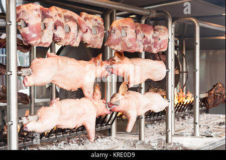 Schlachtkörper von Schweinefleisch und anderen Fleisch am Spieß zubereitet. Kochen am Grill und Feuer. Stockfoto