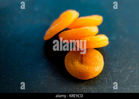 Getrocknete Aprikosen, Ansicht von oben, Makro. Nahaufnahme des Gelben getrockneten Früchten, schwarzen Hintergrund. Stockfoto