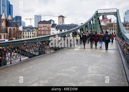 Frankfurt, Deutschland. Junge Menschen laufen auf Eiserner Steg, Bügeleisen Fußgängerbrücke, eiserne Brücke über den Fluss Main City Center verbindet mit Sachsenhausen Stockfoto