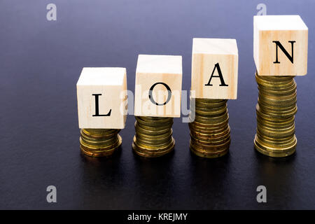 Darlehen Wort auf Holz oben auf Münzen Stapeln. Stockfoto