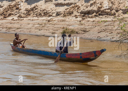 Ein madagassischer Mann und ein Junge Paddel ihren Einbaum auf Mania River. Madagaskar, Afrika. Stockfoto