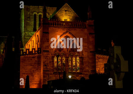 St. Mary's Parish Church, Haddington, East Lothian, Schottland, Vereinigtes Königreich. 19. Dez 2017. Die schöne religiöse Glasmalerei West Fenster in St Marys Kirche leuchtet in einer Winternacht. Es ist die längste Kirche in Schottland. Die Kirche wurde von Cromwells Armee bei der Belagerung von Haddington in 1548-49 zerstört während der "Rough Umwirbt', hat aber viele Umbauten im Laufe der Jahre hatte. Der Turm wurde nie wieder aufgebaut. Die äußeren Wände zeigen noch Pockennarben der Kugeln auf es von Cromwells Armee feuerte Stockfoto