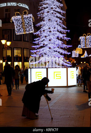 Budapest, Ungarn. 19 Dez, 2017. BUDAPEST, Ungarn - 19 Dezember: ein Bettler bittet um Almosen unter Weihnachtsschmuck am 'Fashion Street" am 19. Dezember in Budapest, Ungarn, 2017. Credit: Laszlo Szirtesi/Alamy leben Nachrichten Stockfoto