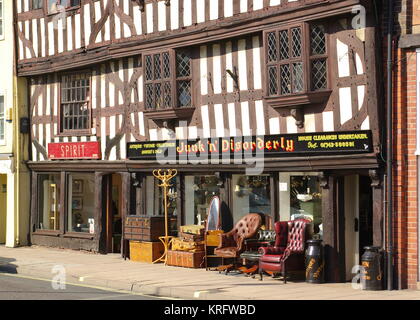 Ein Antiquitäten- und Gebrauchtmöbelgeschäft namens Junk and Disorder in der Stadt Shrewsbury, Shropshire, mit verschiedenen Gegenständen auf dem Bürgersteig. Stockfoto