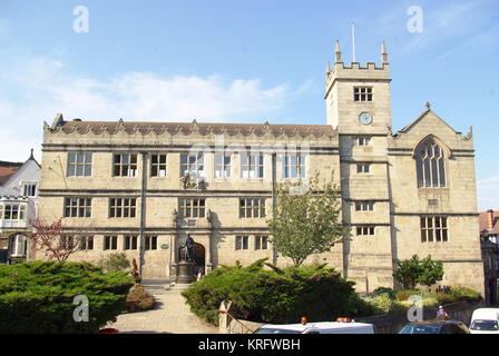 Die öffentliche Bibliothek in Shrewsbury, Shropshire. Es war die ehemalige Shrewsbury School, an der der viktorianische Wissenschaftler Charles Darwin als Junge teilnahm. Eine Statue von Darwin steht vor dem Gebäude. Stockfoto