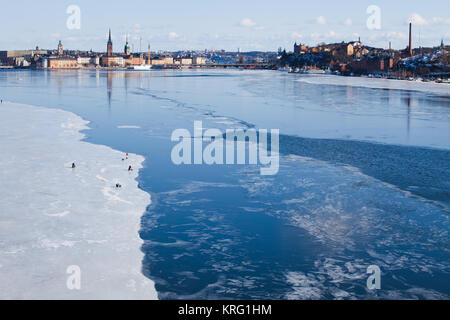 Eisfischen auf dem zugefrorenen Bucht Riddarfjärden, Mälaren. Der Hintergrund Riddarholmen Södermalm auf der linken und auf der rechten Seite. Stockfoto