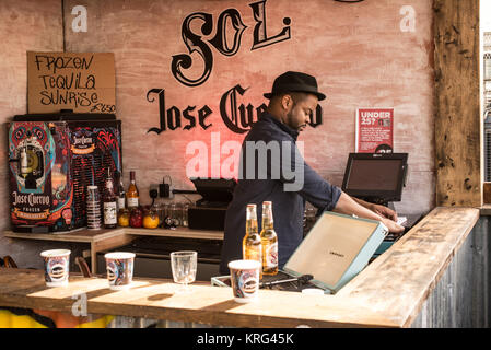 Barkeeper in einer Garküche verkauf Cocktails an der Pop-up Street Food Markt Ort namens Dinerama populär unter jungen trendigen Menschen in Shoreditch Hof, 1. Stockfoto