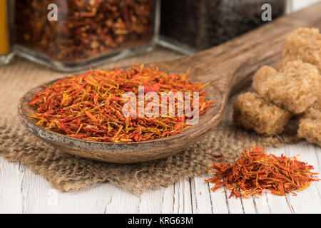 Safran in einem Löffel aus Holz und eine alte weiße Holztisch. Stockfoto