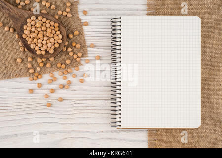 Kichererbsen in einem Kochlöffel auf alten Holztisch. Stockfoto