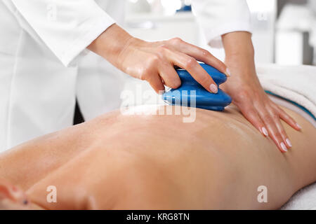 Massageraum, Rückenmassage mit einer chinesischen Glühbirne. Stockfoto