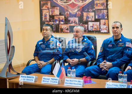 Expedition 38 Bordingenieur Koichi Wakata der Japan Aerospace Exploration Agency, Links, Sojus Commander Mikhail Tyurin von Roskosmos, und Flugingenieur Rick Mastracchio der NASA, Recht, sind hinter Glas gesehen, während in Quarantäne, während die Staatliche Kommission Tagung der Sojus Start der Mannschaft für einen sechsmonatigen Mission an Bord der Internationalen Raumstation, Mittwoch, November 6, 2013 an der Kosmonaut Hotel in Baikonur, Kasachstan, zu genehmigen. Eine olympische Fackel, die mit der Mannschaft für einen 4-tägigen Besuch der Station gestartet wird, ist auf der linken Seite gesehen. Die Fackel wird auf die Erde zurück mit Stockfoto