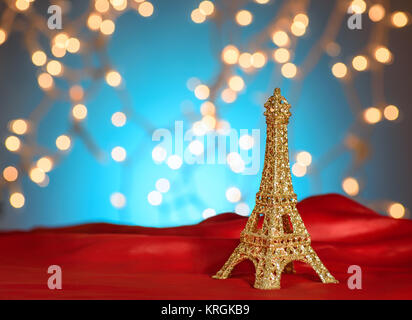 Valentinstag in Paris. Weihnachten, Neujahr in Paris. Golden Eiffelturm auf hellen roten Satin. Verschwommen Weihnachtsbeleuchtung Hintergrund. Kopieren Sie Platz. Stockfoto