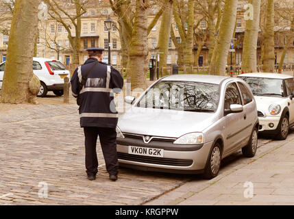 April 2014 - Verkehrspolizist Inverkehrbringen ein Parkticket auf einem Auto Windschutzscheibe in Queen Square, Bristol, England. Stockfoto