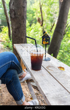 Asiatische Mädchen entspannen Zeit mit kaltem Getränk auf hölzernen Tisch Lifestyle in der Natur Stockfoto