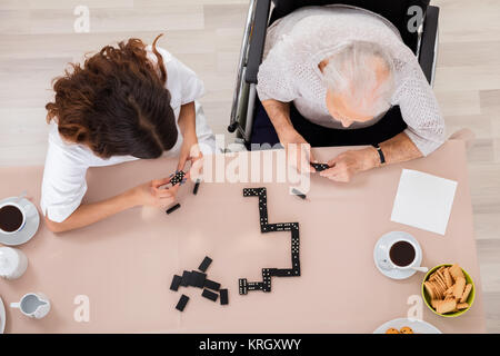 Ältere Frau spielen Domino Spiel mit ihrer Amme Stockfoto