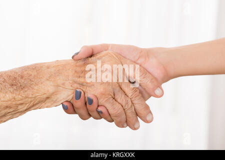 Ältere Patienten zitternden Hand mit weiblichen Arzt Stockfoto